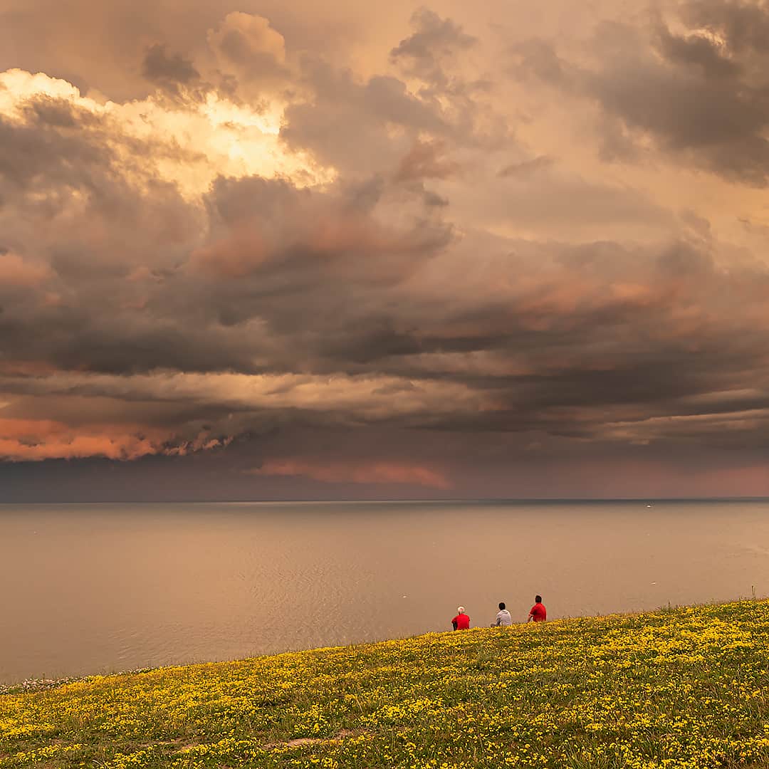 three people looking out over Lake Ontario on Canada Day at East Point Park